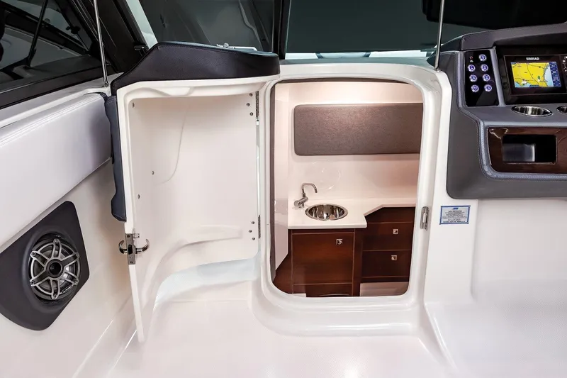 Slide: The Image of 2025 Chaparral 280 OSX boat interior with open door, sink, and navigation system. - 14