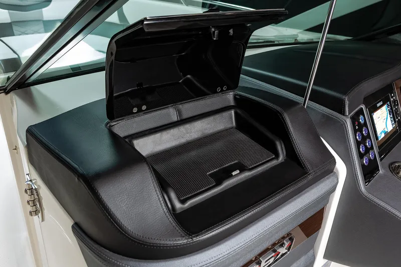 Slide: The Image of 2025 Chaparral 280 OSX boat dashboard with open storage compartment. - 36
