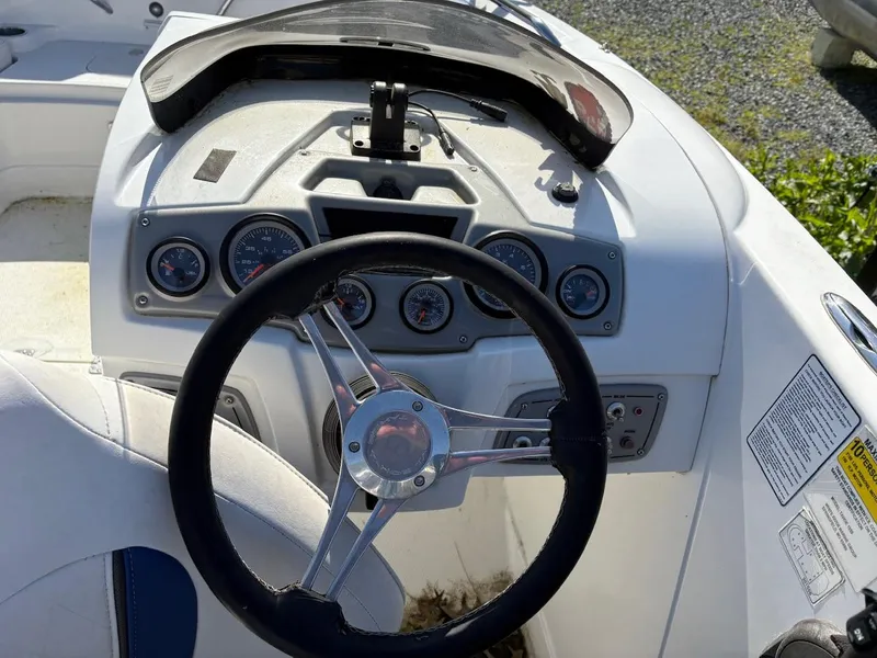 Slide: The Image of Steering wheel and dashboard of a 2020 Tahoe 1950 boat, featuring multiple gauges. - 6