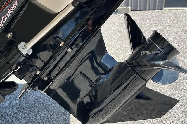 Slide: The Image of 2021 Stingray 225 SE boat engine with Black Max propeller on a gravel surface. - 3