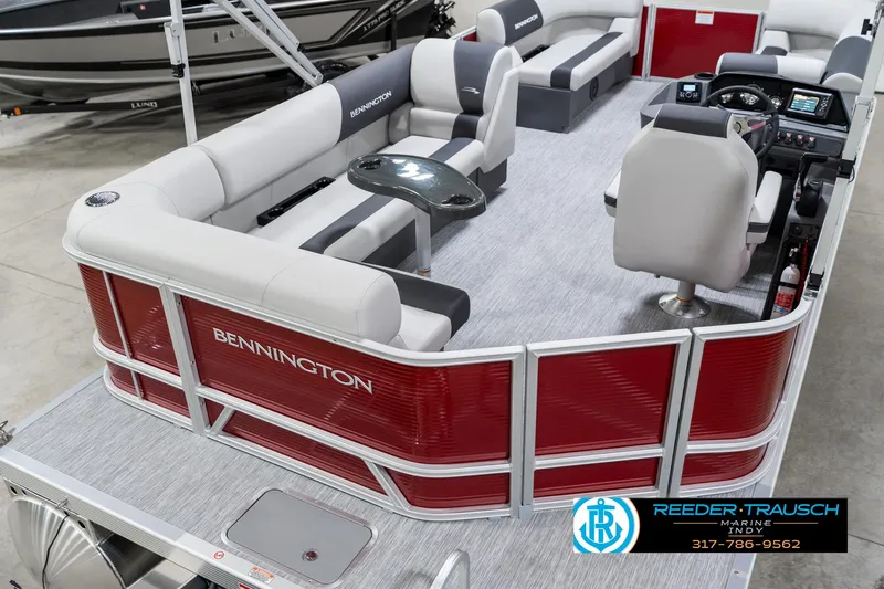 Slide: The Image of 2025 Bennington 20 SL pontoon boat with spacious seating and modern design in a showroom. - 14