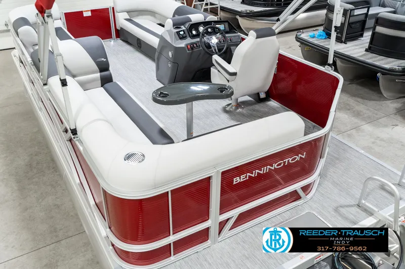 Slide: The Image of 2025 Bennington 20 SL pontoon boat with red and white seating, showcased indoors. - 15
