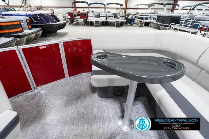 Slide: The Image of 2025 Bennington 20 SL pontoon boat interior with gray seating and table, showroom display. - 18
