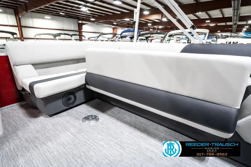 Slide: The Image of 2025 Bennington 20 SL pontoon boat interior with gray and white seating in a showroom. - 27