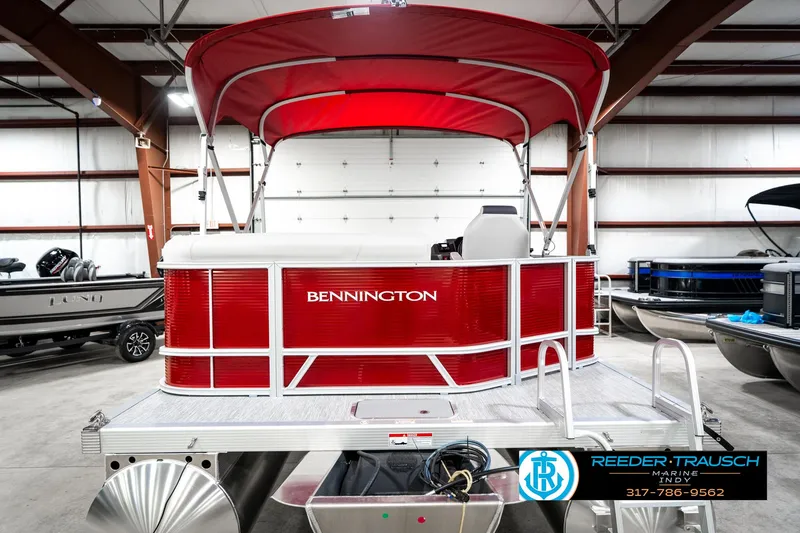 Slide: The Image of 2025 Bennington 20 SL pontoon boat with red canopy in a showroom. - 9