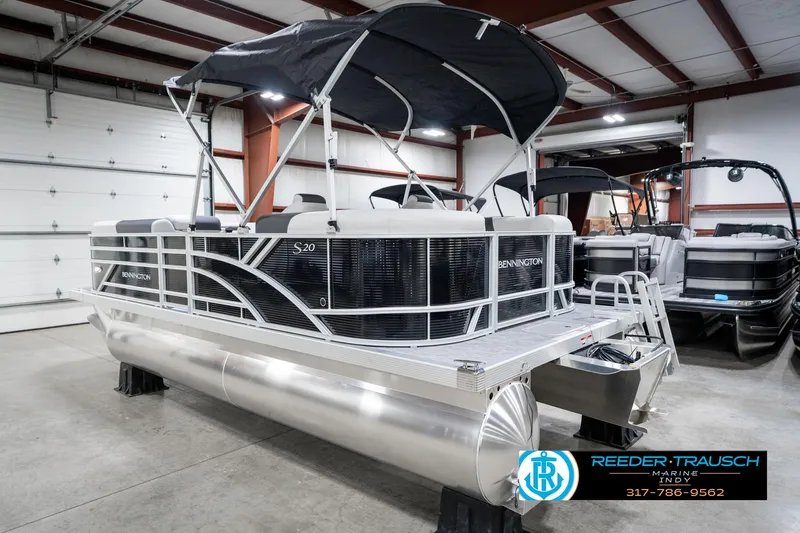Slide: The Image of 2025 Bennington 20 SSR pontoon boat in showroom, featuring sleek design and canopy. - 11