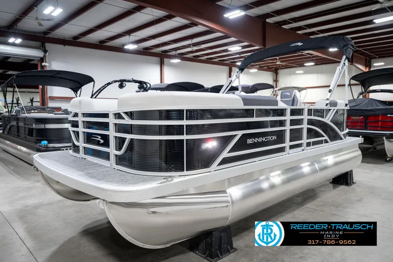 Slide: The Image of 2025 Bennington 20 SSR pontoon boat in showroom, sleek design, silver and black accents. - 3