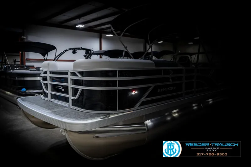 Slide: The Image of 2025 Bennington 20 SSR pontoon boat in a dimly lit showroom. - 5