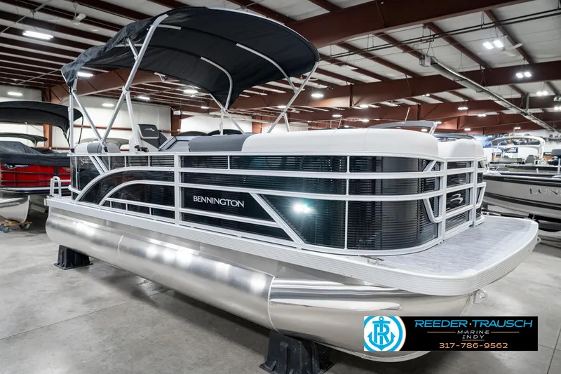 Slide: The Image of 2025 Bennington 20 SSR pontoon boat in showroom, featuring sleek design and canopy. - 7