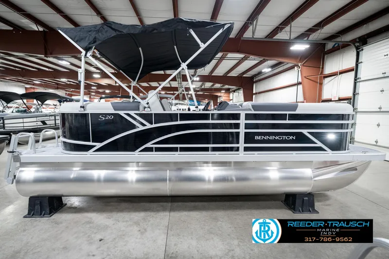 Slide: The Image of 2025 Bennington 20 SSR pontoon boat in showroom, featuring sleek design and black canopy. - 8