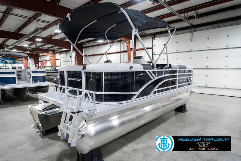 Slide: The Image of 2025 Bennington 20 SSR pontoon boat in showroom, featuring sleek design and canopy. - 9