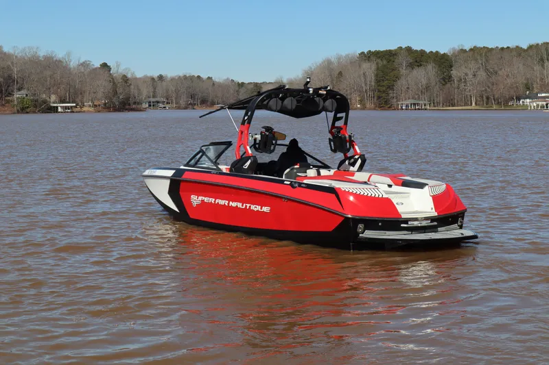 Slide: The Image of 2018 Nautique Super Air Nautique G25 boat on a calm lake, featuring a sleek red and white design. - 3