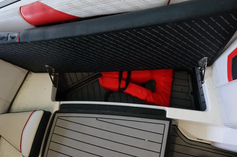 Slide: The Image of 2018 Nautique Super Air Nautique G25 storage compartment with red life jacket inside. - 7