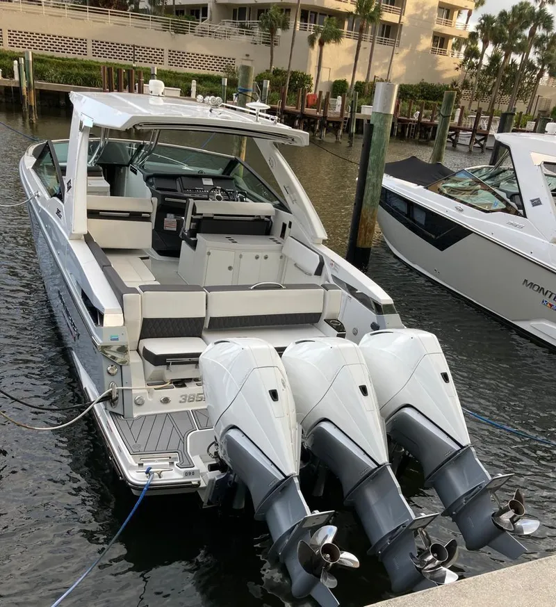 Slide: The Image of 2022 Monterey 385 Super Express boat docked with triple outboard engines. - 0