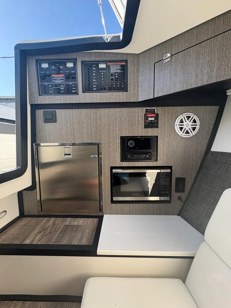 Slide: The Image of 2022 Monterey 385 Super Express interior with control panels, fridge, and seating. - 13
