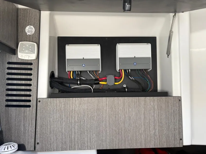 Slide: The Image of Electrical panel inside 2022 Monterey 385 Super Express boat, featuring dual control units and wiring. - 15