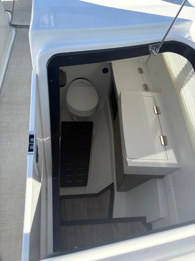Slide: The Image of 2022 Monterey 385 Super Express boat interior with compact bathroom and storage cabinets. - 19
