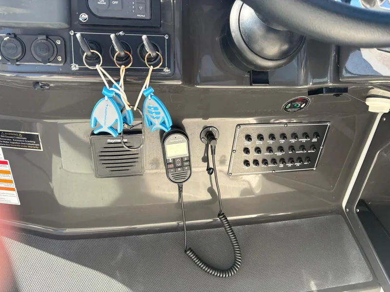 Slide: The Image of Control panel of a 2022 Monterey 385 Super Express boat with keys and communication devices. - 24