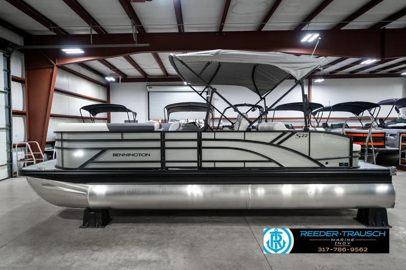 Slide: The Image of 2025 Bennington 22 SSB pontoon boat in a showroom with canopy and sleek design. - 11