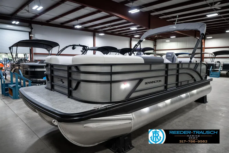 Slide: The Image of 2025 Bennington 22 SSB pontoon boat in showroom, featuring sleek design and modern amenities. - 2