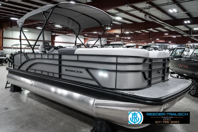 Slide: The Image of 2025 Bennington 22 SSB pontoon boat in showroom with canopy and sleek design. - 6