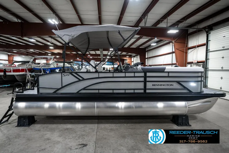 Slide: The Image of 2025 Bennington 22 SSB pontoon boat in showroom, featuring sleek design and canopy. - 7