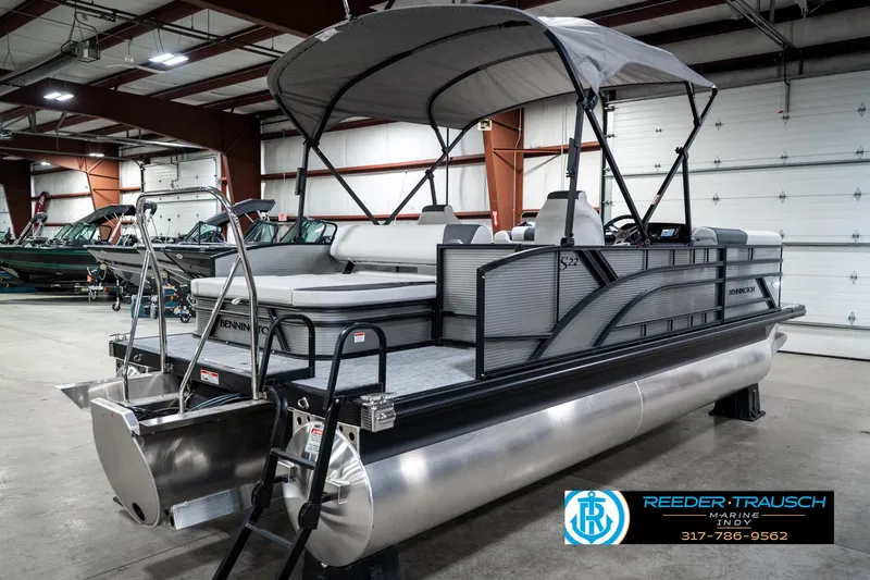 Slide: The Image of 2025 Bennington 22 SSB pontoon boat in showroom, featuring sleek design and canopy. - 8