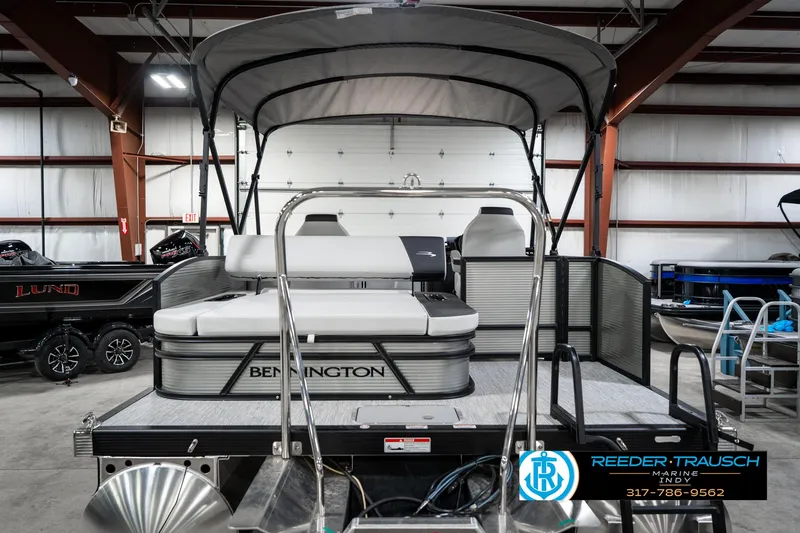 Slide: The Image of 2025 Bennington 22 SSB pontoon boat in showroom, featuring sleek design and comfortable seating. - 9