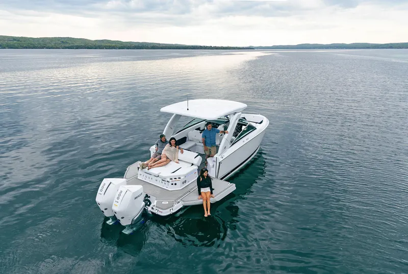 Slide: The Image of 2025 Four Winns H9C boat on a lake with people enjoying the water. - 4