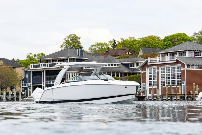 Slide: The Image of 2025 Four Winns H9C boat on water near waterfront homes. - 6