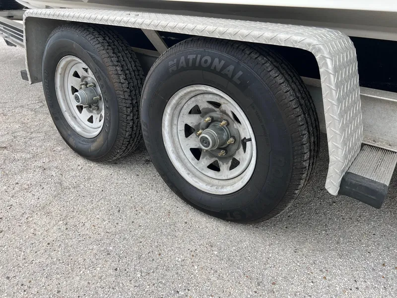 Slide: The Image of Trailer wheels of a 1998 Boston Whaler 26 Outrage on a textured metal fender. - 1