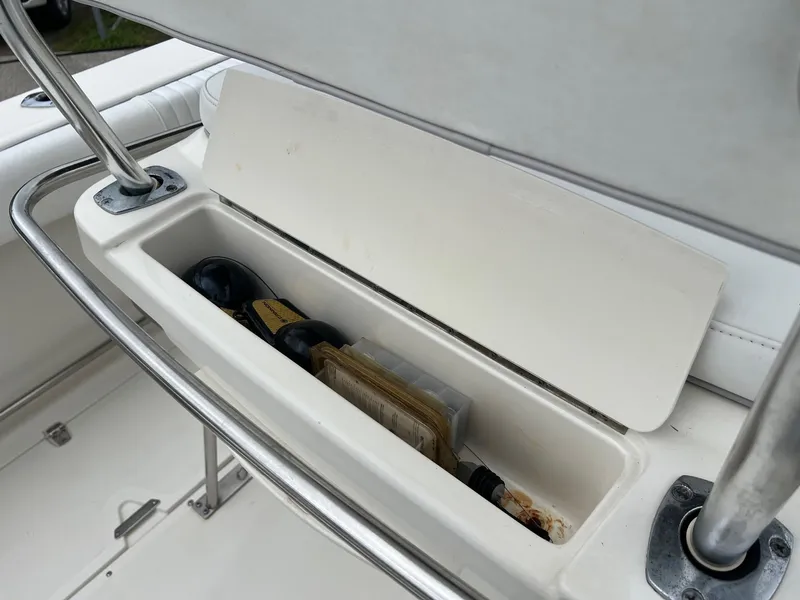 Slide: The Image of Storage compartment on a 1998 Boston Whaler 26 Outrage boat, containing bottles and items. - 13
