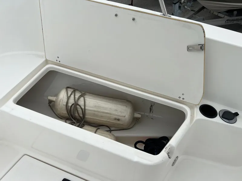 Slide: The Image of Open storage compartment on a 1998 Boston Whaler 26 Outrage boat with fender inside. - 17