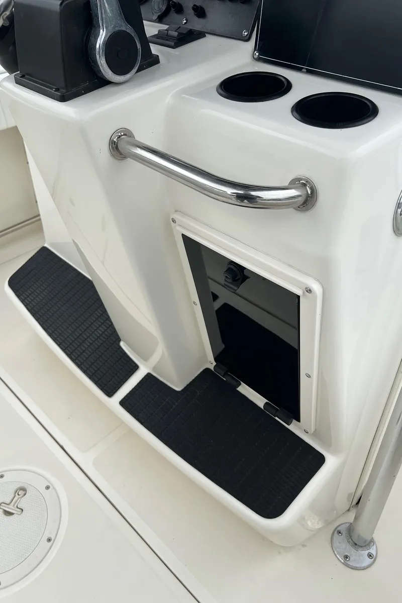 Slide: The Image of 1998 Boston Whaler 26 Outrage console with cup holders and storage compartment. - 25
