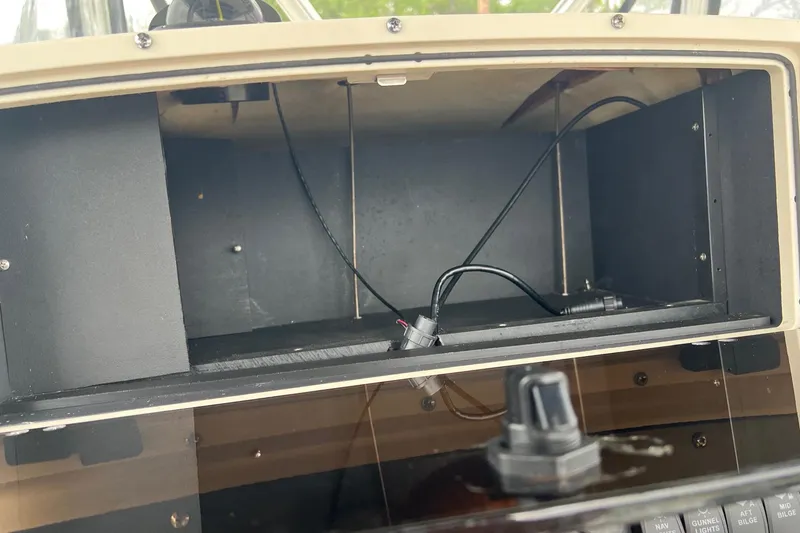 Slide: The Image of Open storage compartment on a 1998 Boston Whaler 26 Outrage boat dashboard. - 26