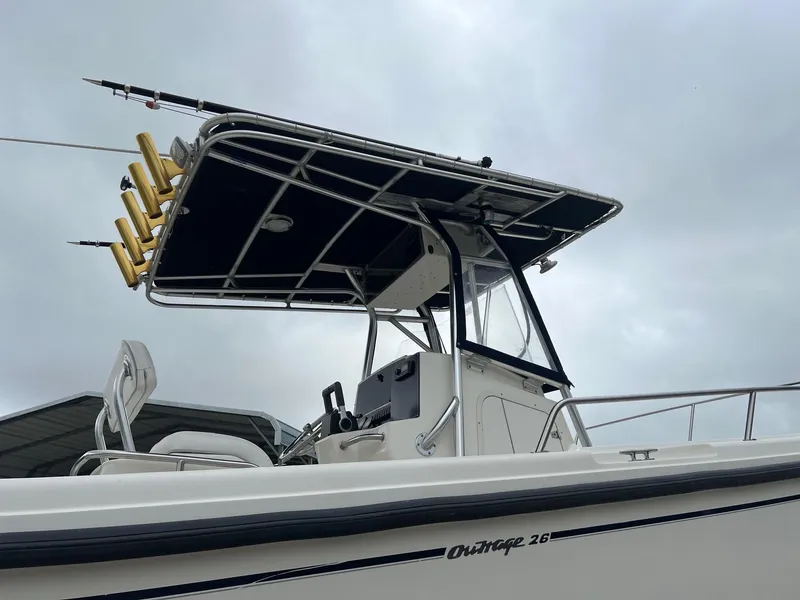 Slide: The Image of 1998 Boston Whaler 26 Outrage boat with T-top and rod holders, side view. - 3