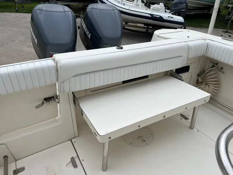 Slide: The Image of 1998 Boston Whaler 26 Outrage boat interior with foldable bench and twin Yamaha engines. - 7