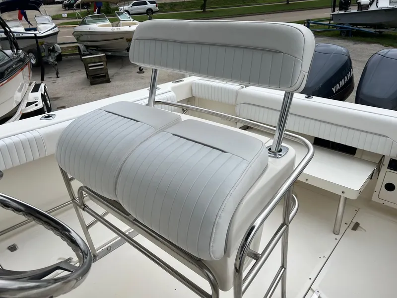 Slide: The Image of 1998 Boston Whaler 26 Outrage boat with white cushioned seating and dual Yamaha engines. - 8