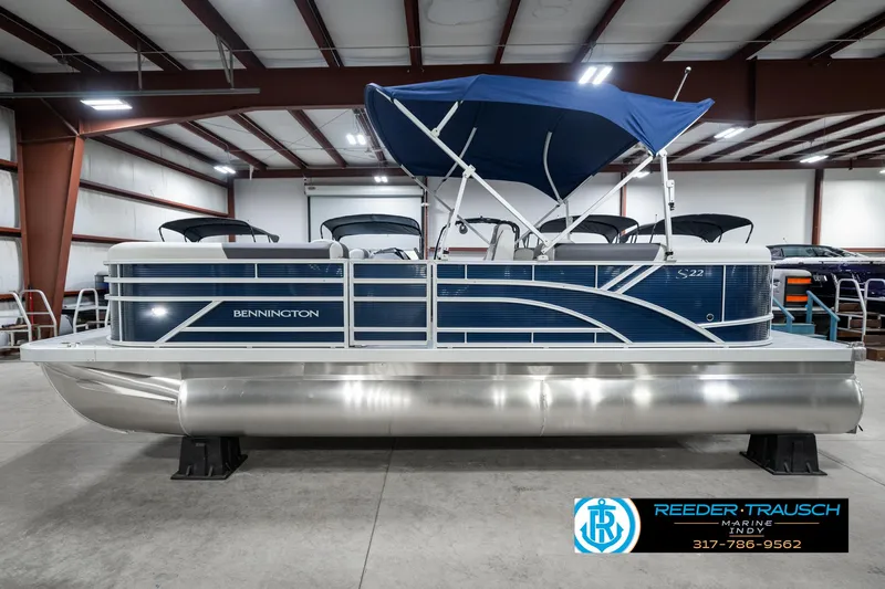 Slide: The Image of 2025 Bennington 22 SSR pontoon boat with blue canopy in showroom. - 11