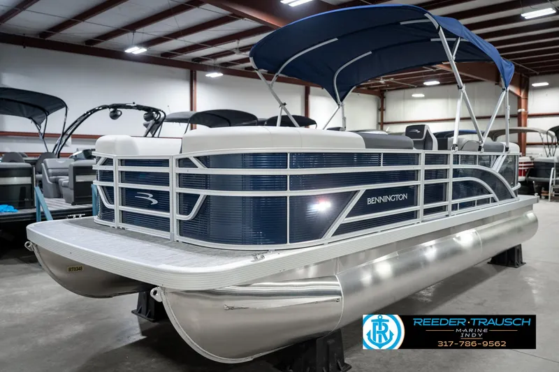Slide: The Image of 2025 Bennington 22 SSR pontoon boat with blue canopy in showroom. - 3
