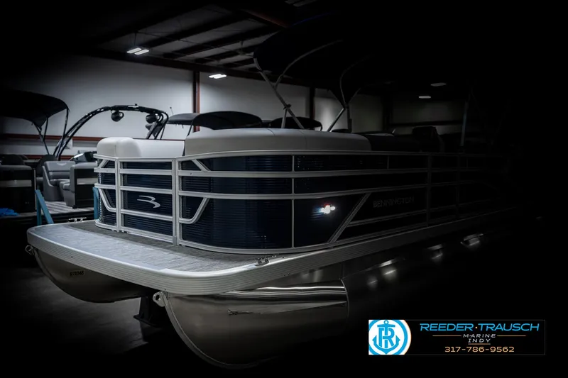 Slide: The Image of 2025 Bennington 22 SSR pontoon boat in a dimly lit showroom. - 4