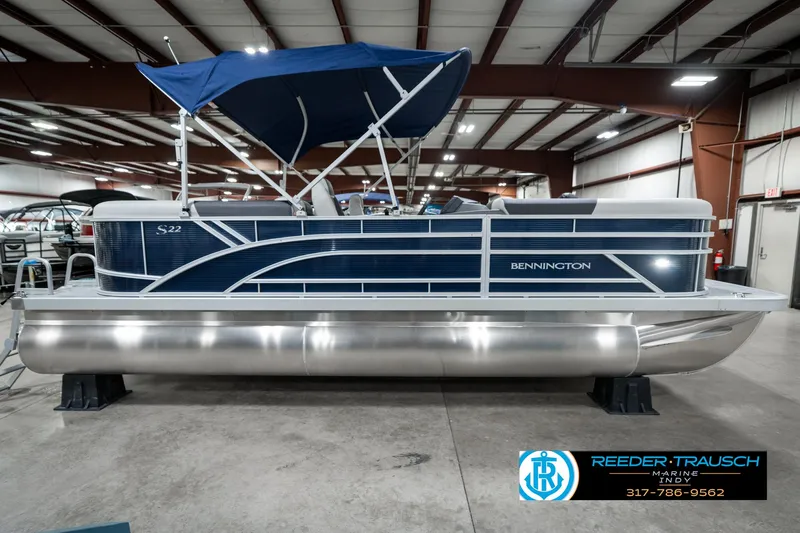 Slide: The Image of 2025 Bennington 22 SSR pontoon boat with blue canopy in showroom. - 7