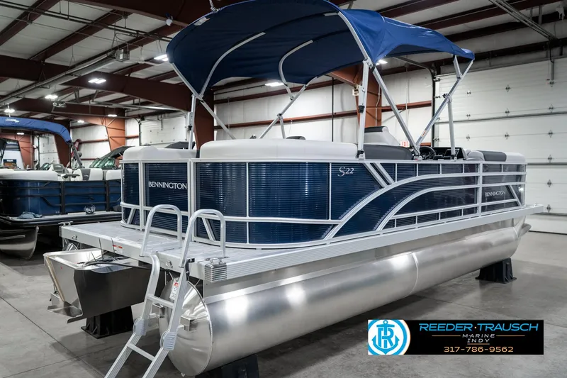 Slide: The Image of 2025 Bennington 22 SSR pontoon boat with blue canopy in showroom. - 8