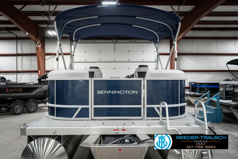 Slide: The Image of 2025 Bennington 22 SSR pontoon boat in showroom with blue canopy. - 9