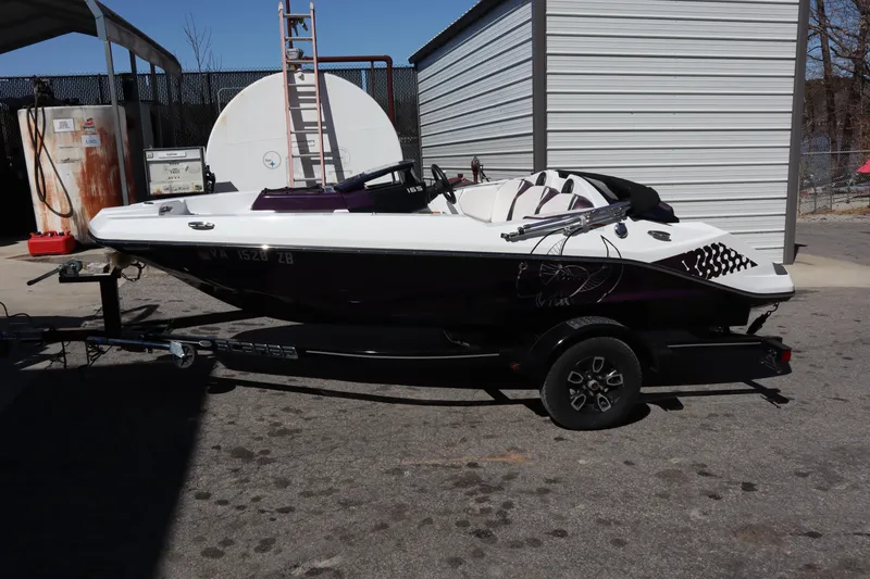 Slide: The Image of 2023 Scarab 165 ID boat on trailer, parked outdoors near storage shed. - 4