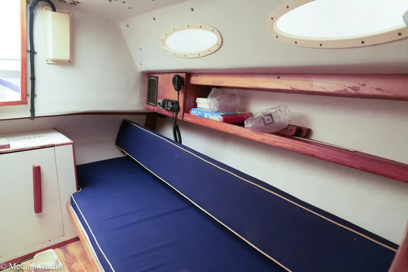 Slide: The Image of Interior of 2002 Alerion Express 28 sailboat with blue cushioned seating and wooden shelves. - 16