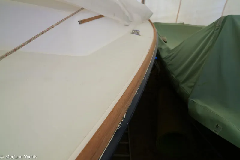 Slide: The Image of 2002 Alerion Express 28 sailboat deck with wooden trim, partially covered. - 23