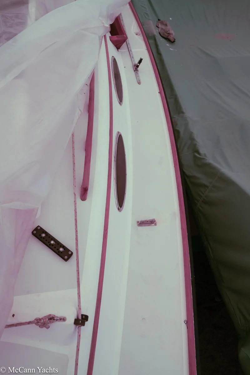 Slide: The Image of 2002 Alerion Express 28 sailboat deck under cover, showing sleek design and portholes. - 25