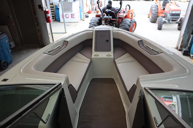 Slide: The Image of 1996 Cobalt 220 boat interior with cushioned seating, open bow, and visible tractor in background. - 14