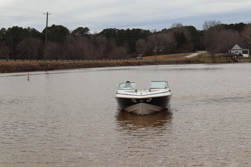Slide: The Image of Cobalt 220 boat from 1996 on a calm lake with wooded shoreline. - 4